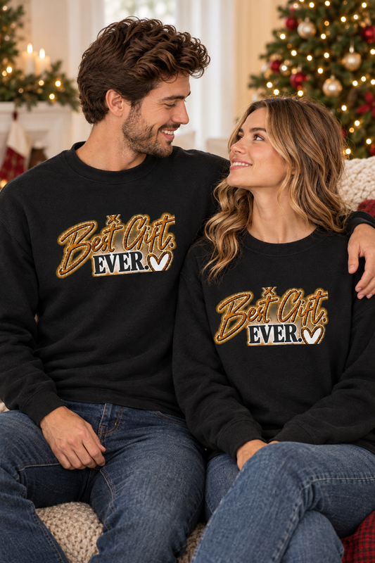 Couple in matching sweatshirts by a Christmas tree